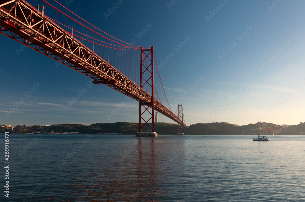 Scenic view of the 25 of April Bridge (Ponte 25 de Abril) over the Tagus River in the city of Lisbon, Portugal; Concept for travel in Portugal Scenic view of the 25 of April Bridge (Ponte 25 de Abril) over the Tagus River in the city of Lisbon, Portugal; Concept for travel in Portugal