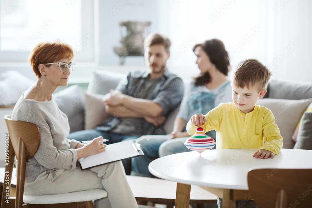 Child playing with spinning top ADHD therapy with parents