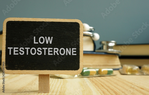 Sign low testosterone and book on wooden surface. photo