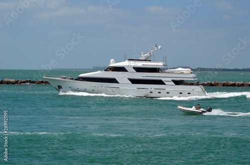 White motor yacht exiting Government Cut in Miami Beach,Florida and heading towards open ocean.
