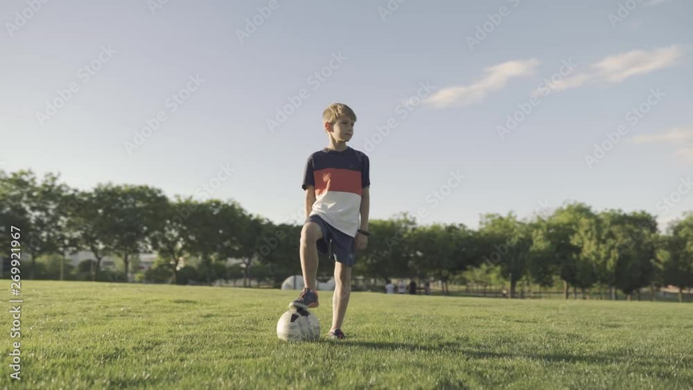 boy playing football in the park boy playing football in the park