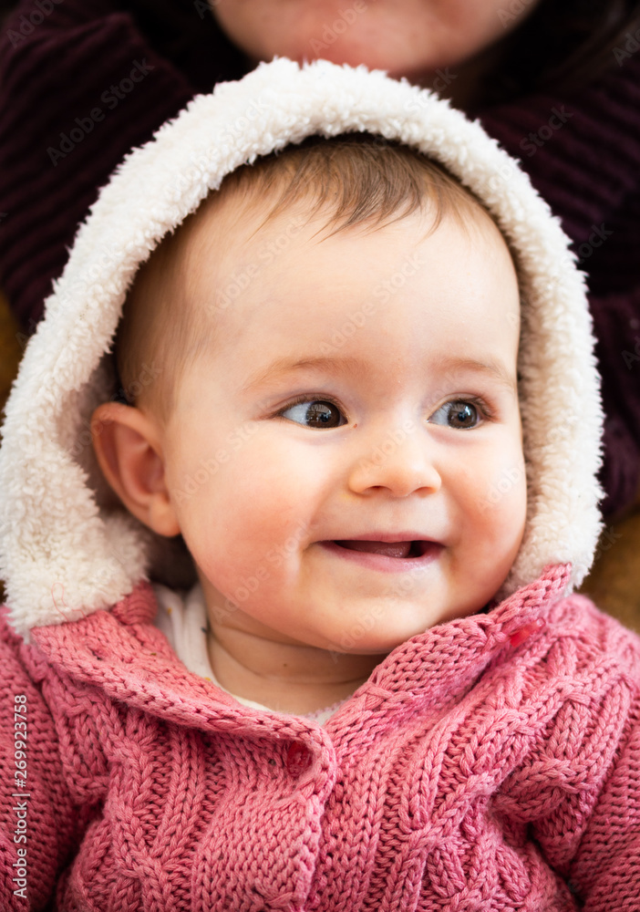 A Portrait of a Happy Baby Face Wearing a Pink Wool Jacket Babyhood, Childhood and People Concept A Portrait of a Happy Baby Face Wearing a Pink Wool Jacket Babyhood, Childhood and People Concept