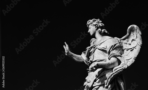 Angel statue holding the Nails of Jesus Cross. A 17th century baroque masterpiece at the top of Sant'Angelo Bridge in the center of Rome (Black and White with copy space)