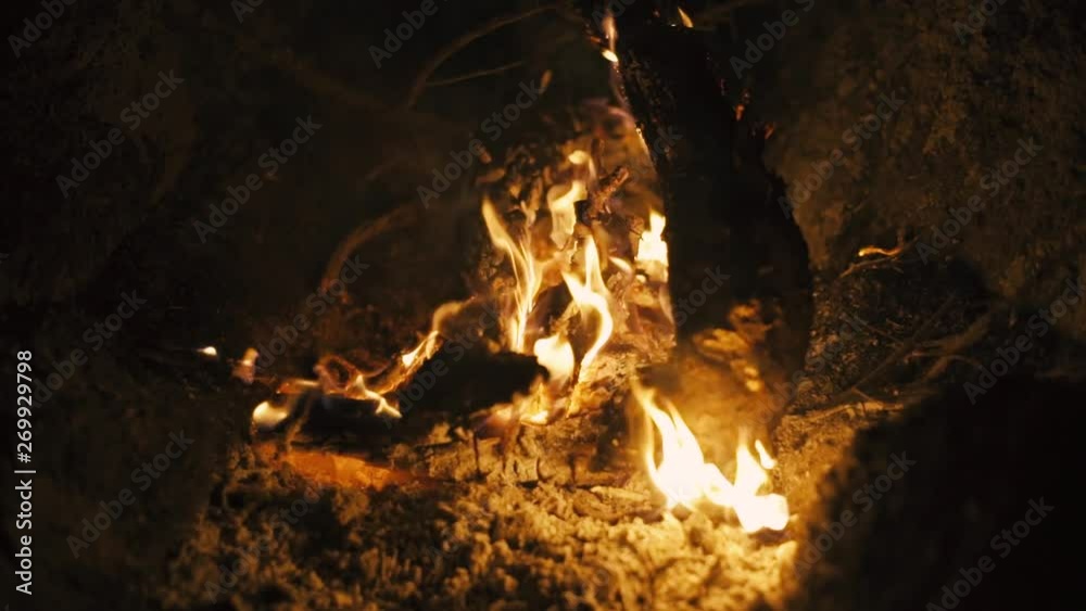 Burn fire with wood on beach or mountain camp. Close-up slow motion shot at night Burn fire with wood on beach or mountain camp. Close-up slow motion shot at night