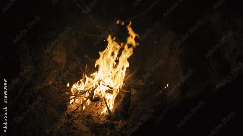 Burn fire with wood on beach or mountain camp. Close-up slow motion shot at night Burn fire with wood on beach or mountain camp. Close-up slow motion shot at night