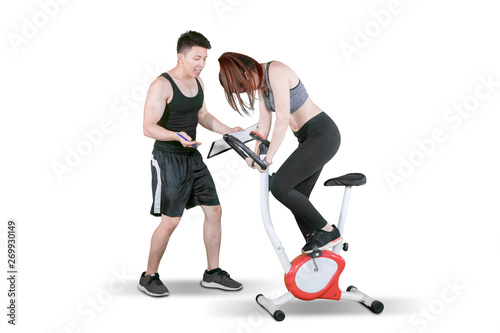 Male trainer giving support her client on studio