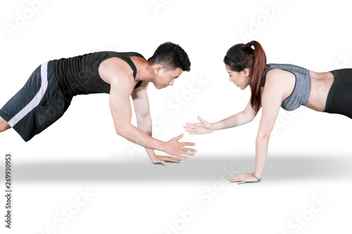 Sporty couple clap hands during push up on studio