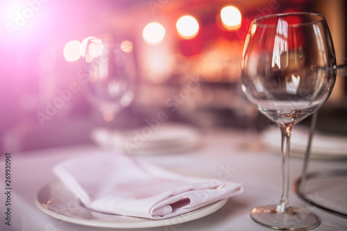 A close up shot of a restaurant table set up with tableware and wine glass. Concept of dining, hospitality and catering. Horizontal image with free space for text.