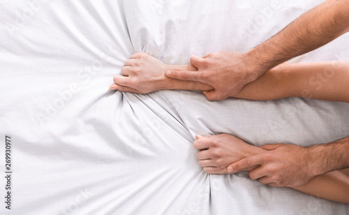 Sexy couple hands pulling white sheets in ecstasy © Prostock-studio