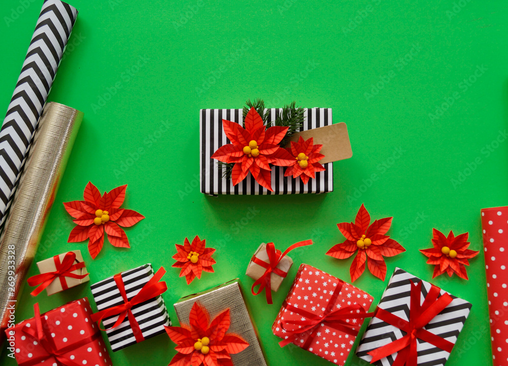 Fototapeta premium The process of packaging Christmas gifts. Poinsettia. New Year.