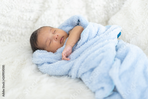 Newborn baby sleeping in bed
