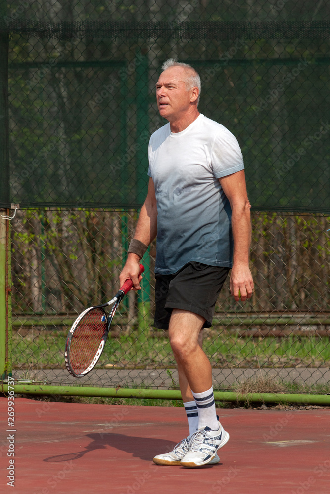 Man playing tennis on the outdoor court