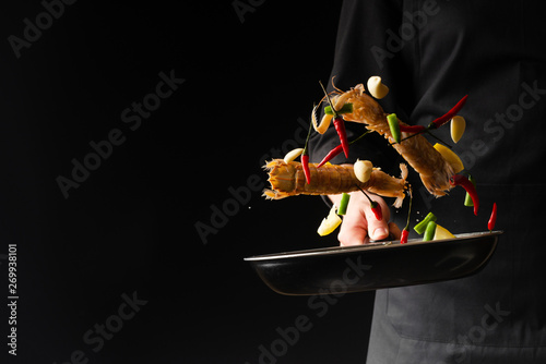 Chef preparing sea food, praying mantis shrimp with lemon and hot pepper and green beans, East Asian cuisine, dilikates, vegetarian cuisine, on a black background, horizontal photo, banner photo