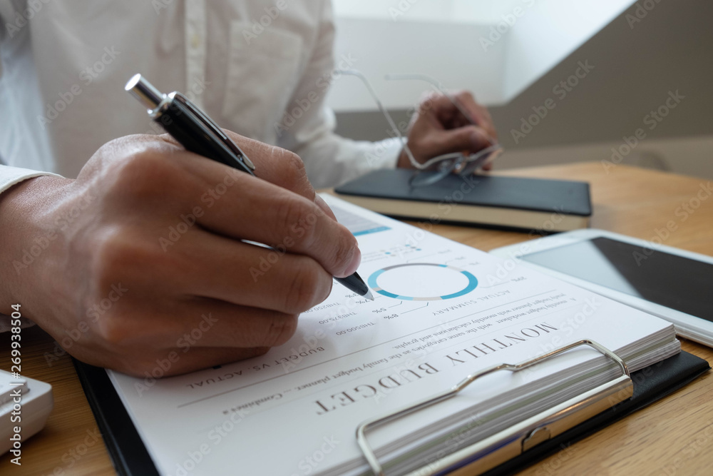 close-up Businessmen financial sitting work checking documents using technology close-up Businessmen financial sitting work checking documents using technology