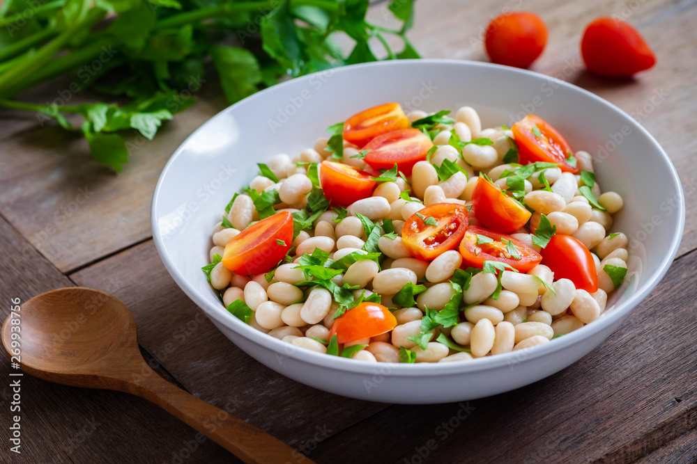 White bean salad with cherry tomatoes and parsley in bowl White bean salad with cherry tomatoes and parsley in bowl