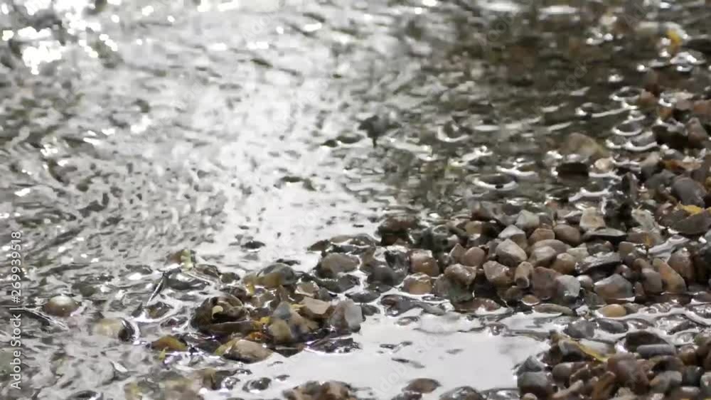 Water rippling on the side of some pebbles Water rippling on the side of some pebbles