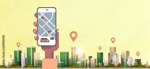 human hand using online ordering taxi car sharing mobile application concept transportation carsharing service app smartphone screen with gps map modern cityscape background horizontal