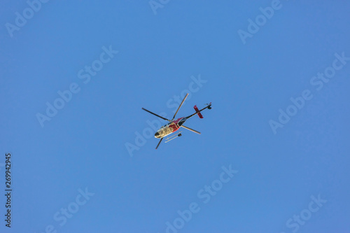 Helicopter flying high with cloudless and clear blue sky in the background