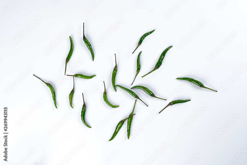 Obraz premium Fresh birds eye green chilli scattered top view on white background