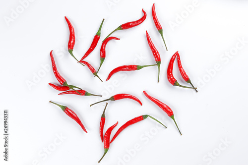 Fresh birds eye red chilli scattered top view on white background