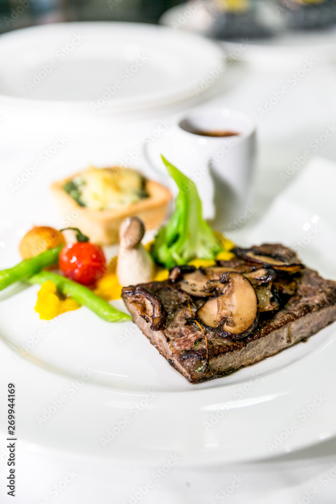 Grilled meat steaks with vegetables, sauce and decoration Grilled meat steaks with vegetables, sauce and decoration