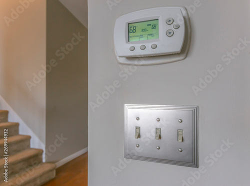 Wall mounted air conditioner unlit control and light switches inside a house