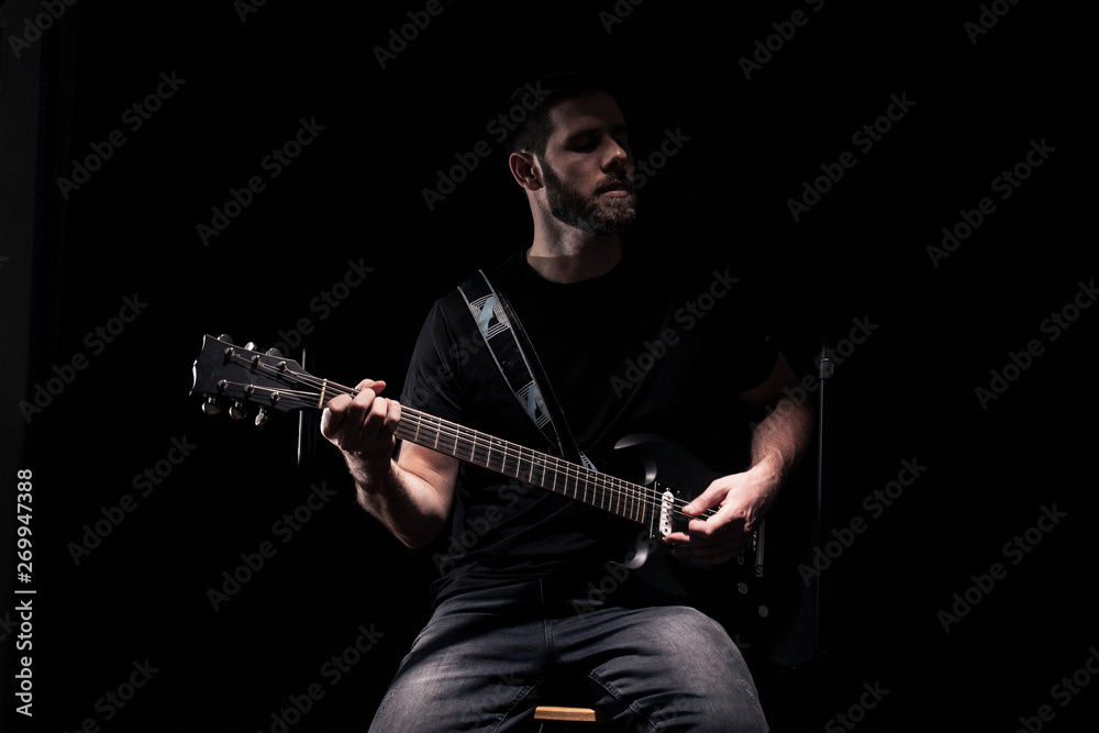Naklejka premium one man, rock or metal musician, almost unrecognizable person, playing a guitar.