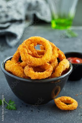 Obraz na plátně Homemade crunchy fried onion rings with tomato sauce