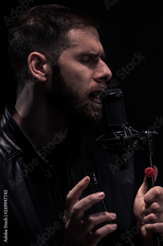 Konstfotografi one man, rock musician singing tensely on a microphone.