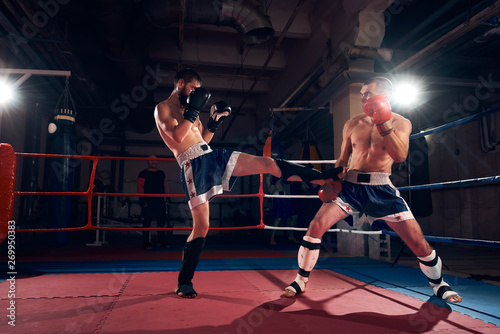 Two angry male kickboxers training kickboxing in the ring at the health club © anatoliy_gleb