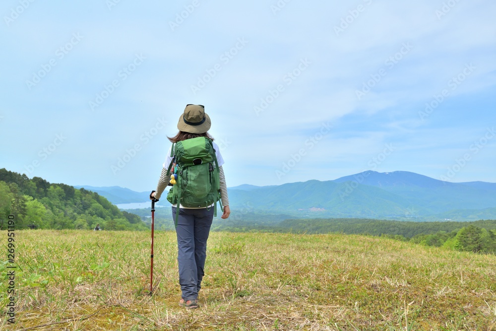 高原のトレッキング・草原を歩く女性