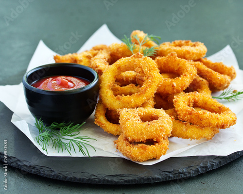 Homemade crunchy fried onion rings with tomato sauce
