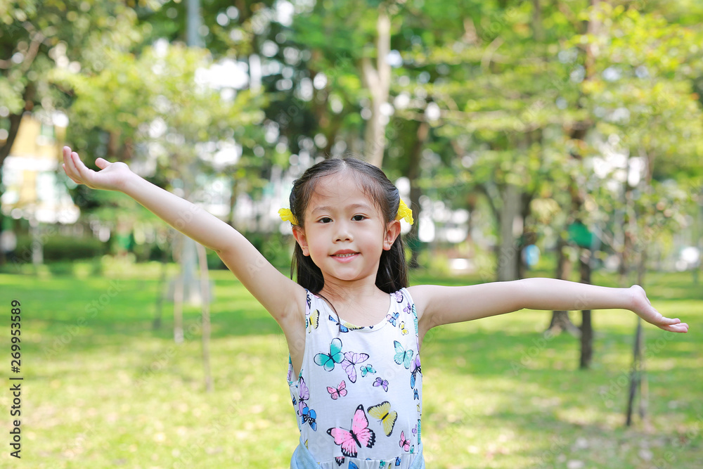 Portrait of smiling little Asian children opened her hands in the green garden. Portrait of smiling little Asian children opened her hands in the green garden.