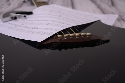Guitar notes on a guitar along with a capo