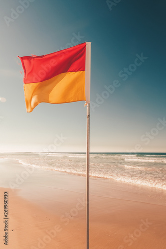 Red yellow flag on the beach
