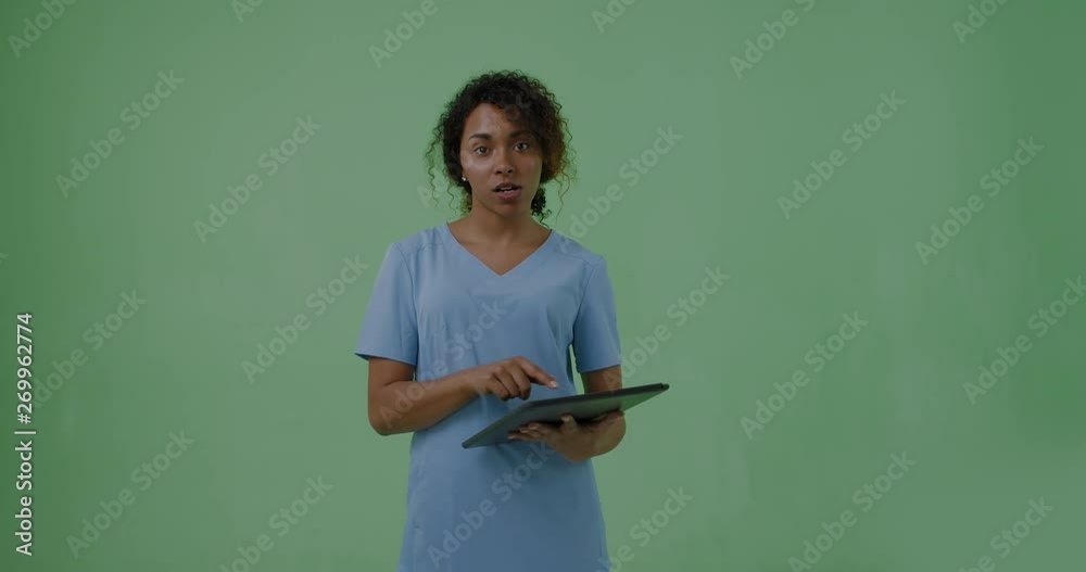 GREEN SCREEN portrait of young attractive African American Black female medic student posing with a tablet portable pc. 4K UHD