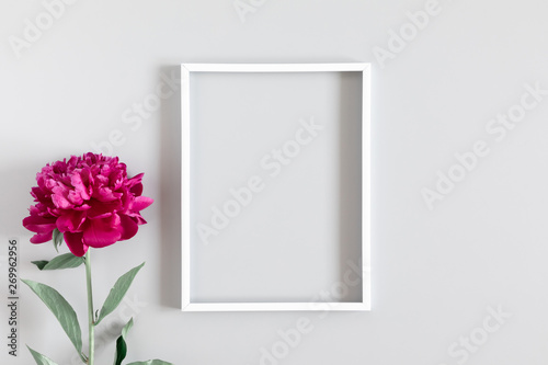 Beautiful flowers composition. Blank frame for text, red peonies flowers on gray background. Flat lay, top view, copy space © prime1001