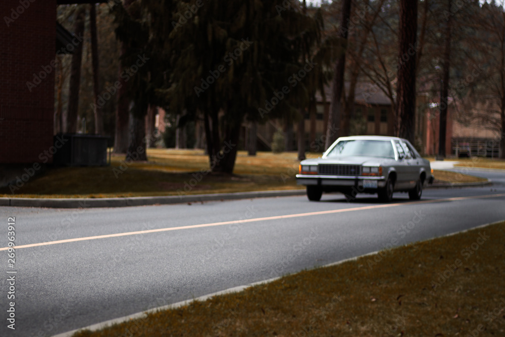 Old car driving in early spring sad and out of focus