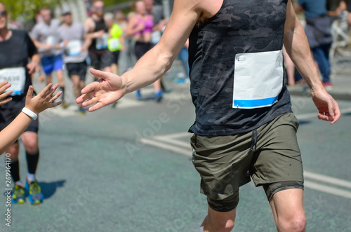 Marathon running race,runners support on road race, child's hand giving highfive, kid supporting athletes who run, sport concept