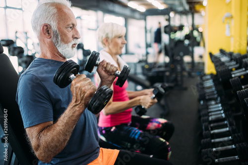 Fit senior sporty couple working out together at gym