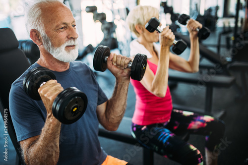Mature fit couple exercising in gym to stay healthy
