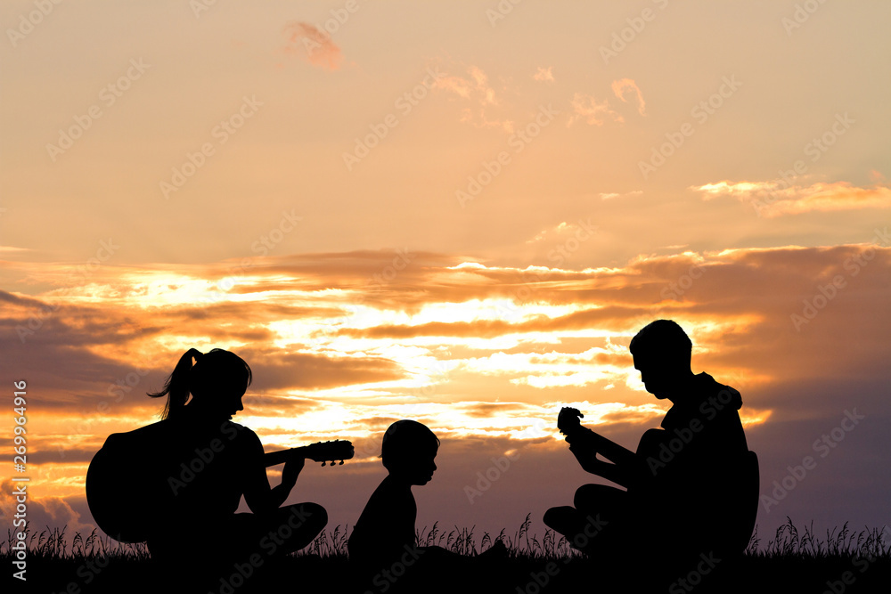 man and woman play guitar and sing at sunset