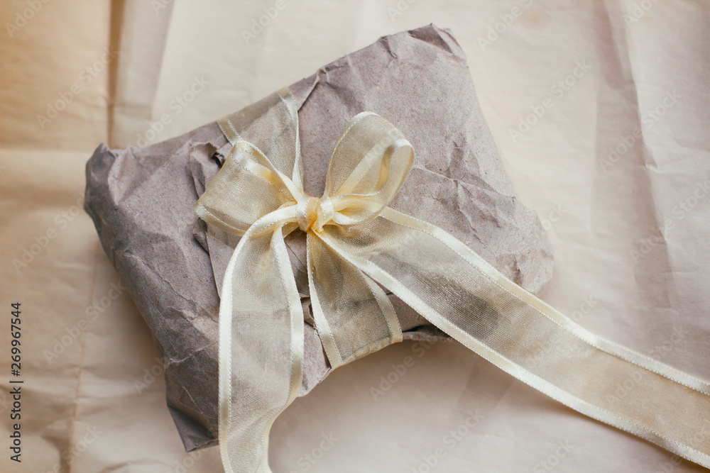 Soft parcel wrapped into old craft paper and tie. Crumpled background texture. Gift shop. Materials for transportation and shipping. Soft parcel wrapped into old craft paper and tie. Crumpled background texture. Gift shop. Materials for transportation and shipping.