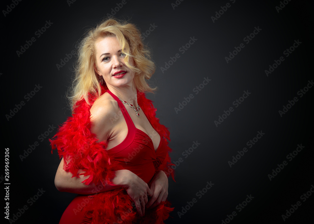 Attractive middle age woman in red evening dress with fluffy feather boa. Attractive middle age woman in red evening dress with fluffy feather boa.