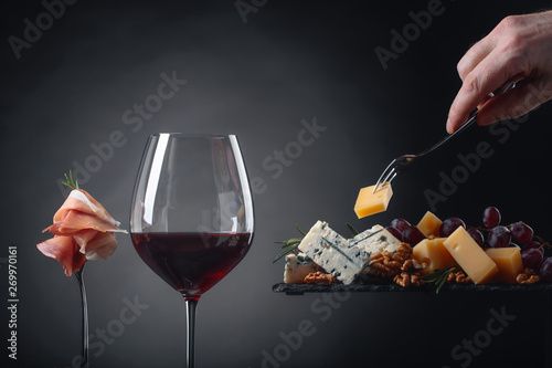 Glass of red wine with various cheeses.