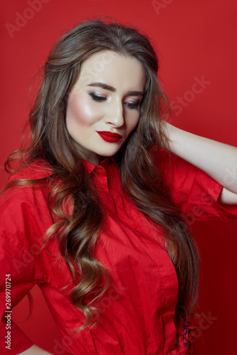 Woman with curly hair red dress on red background