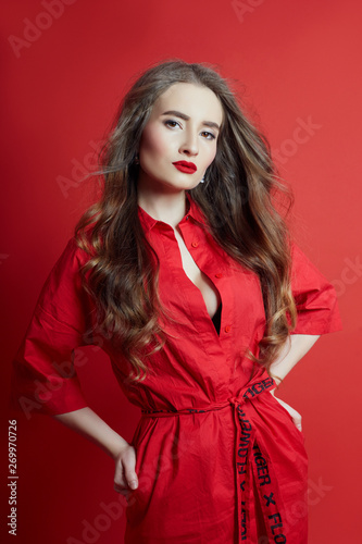 Woman with curly hair red dress on red background