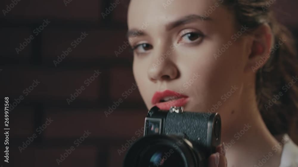 Beautiful woman using retro photo camera. Girl photographer working in studio Beautiful woman using retro photo camera. Girl photographer working in studio