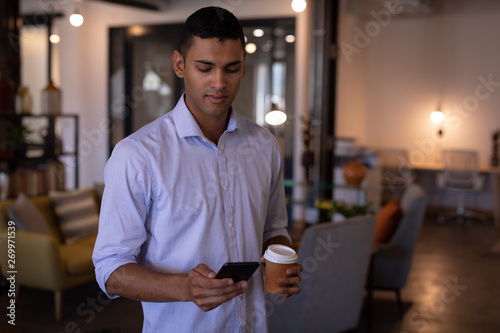 Businessman using mobile phone in office photo