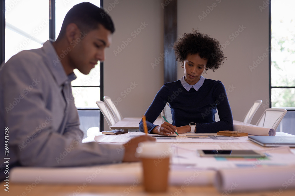 Business people working on plans in a meeting room Business people working on plans in a meeting room